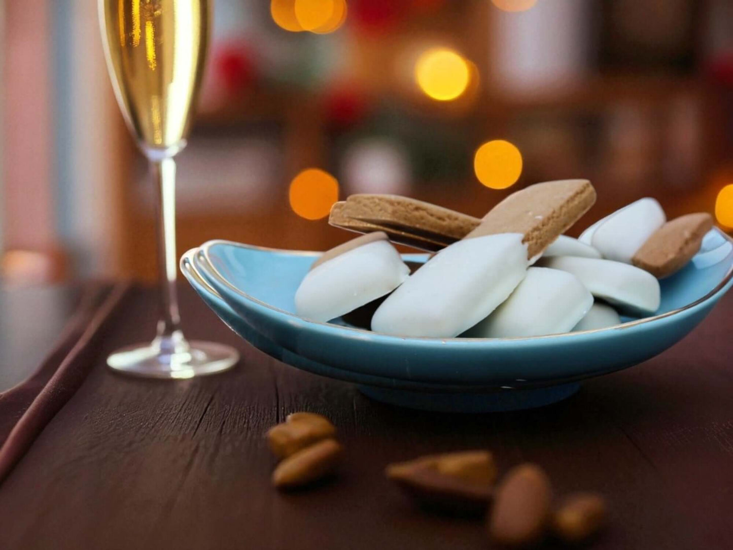 Bowl of cookies next to a glass of champagne on a festive background