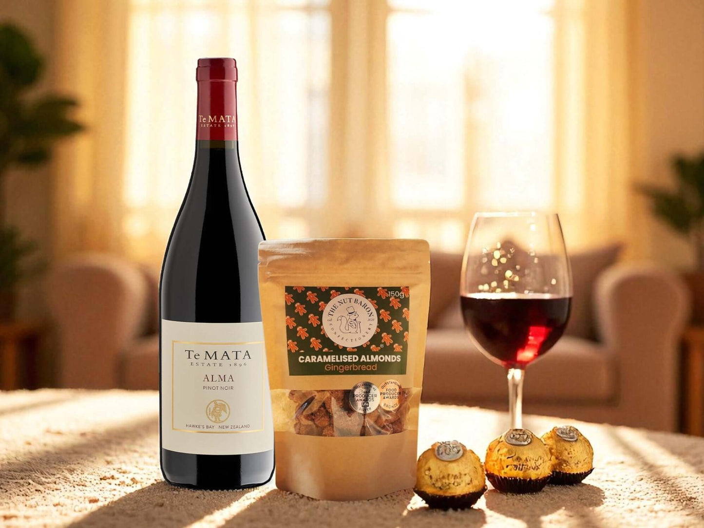 Te Mata Alma wine bottle with a glass of wine and a bag of caramelized almonds on a table.
