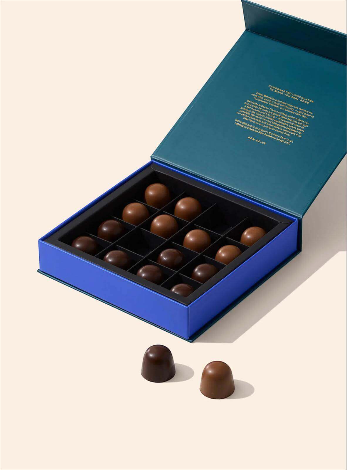 Open blue chocolate box with chocolates on a beige background