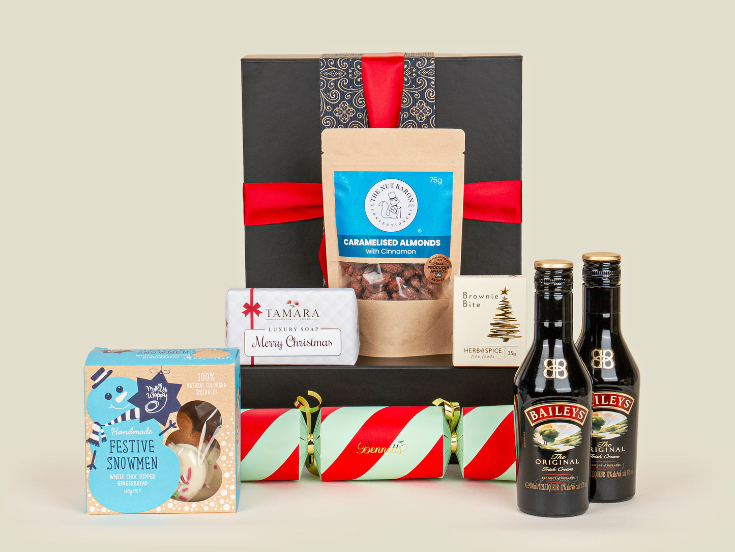 Gift basket with Baileys bottles and festive items on a light background