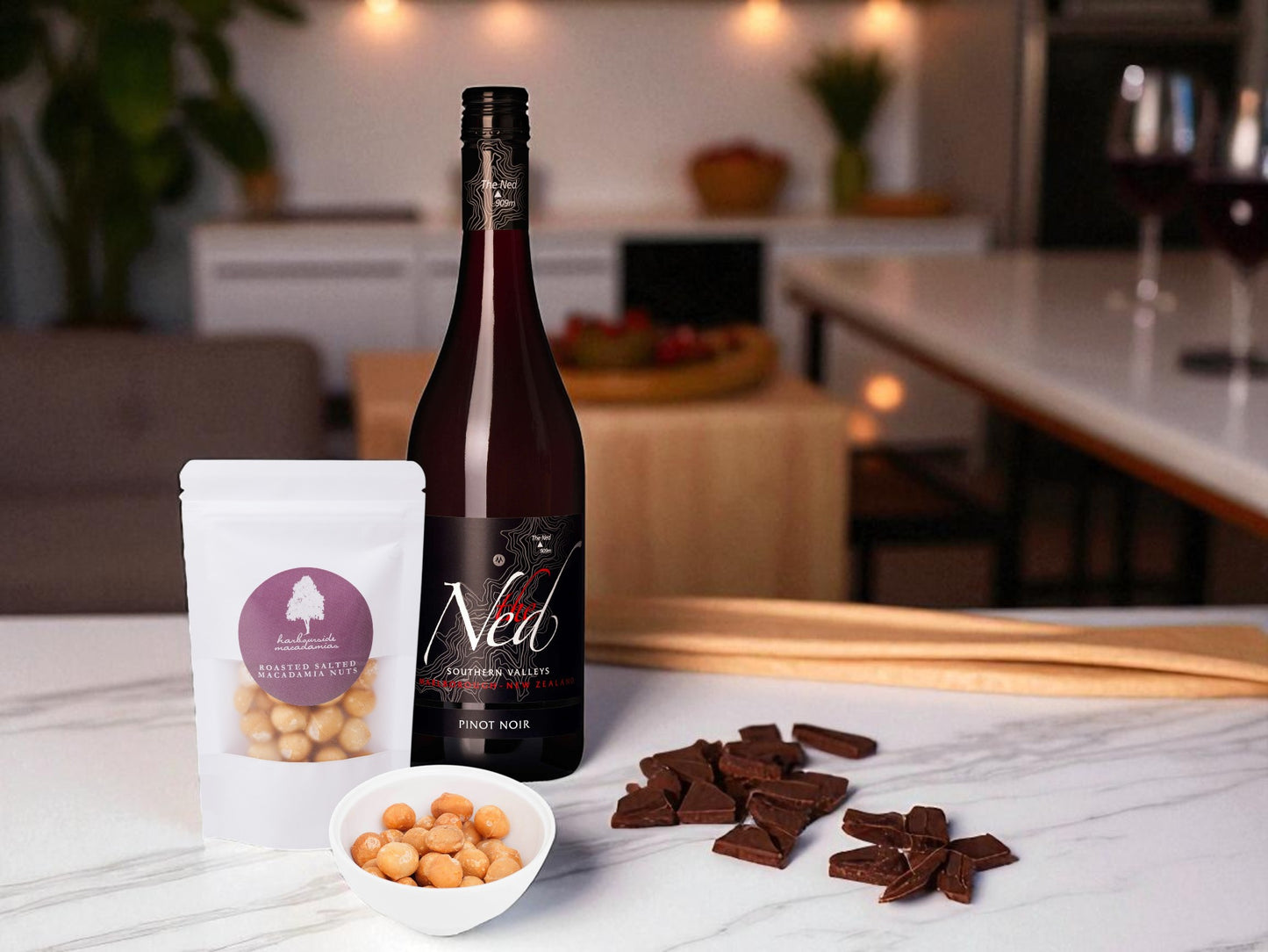 Bottle of Ned wine with a bag of nuts and chocolate pieces on a kitchen counter.