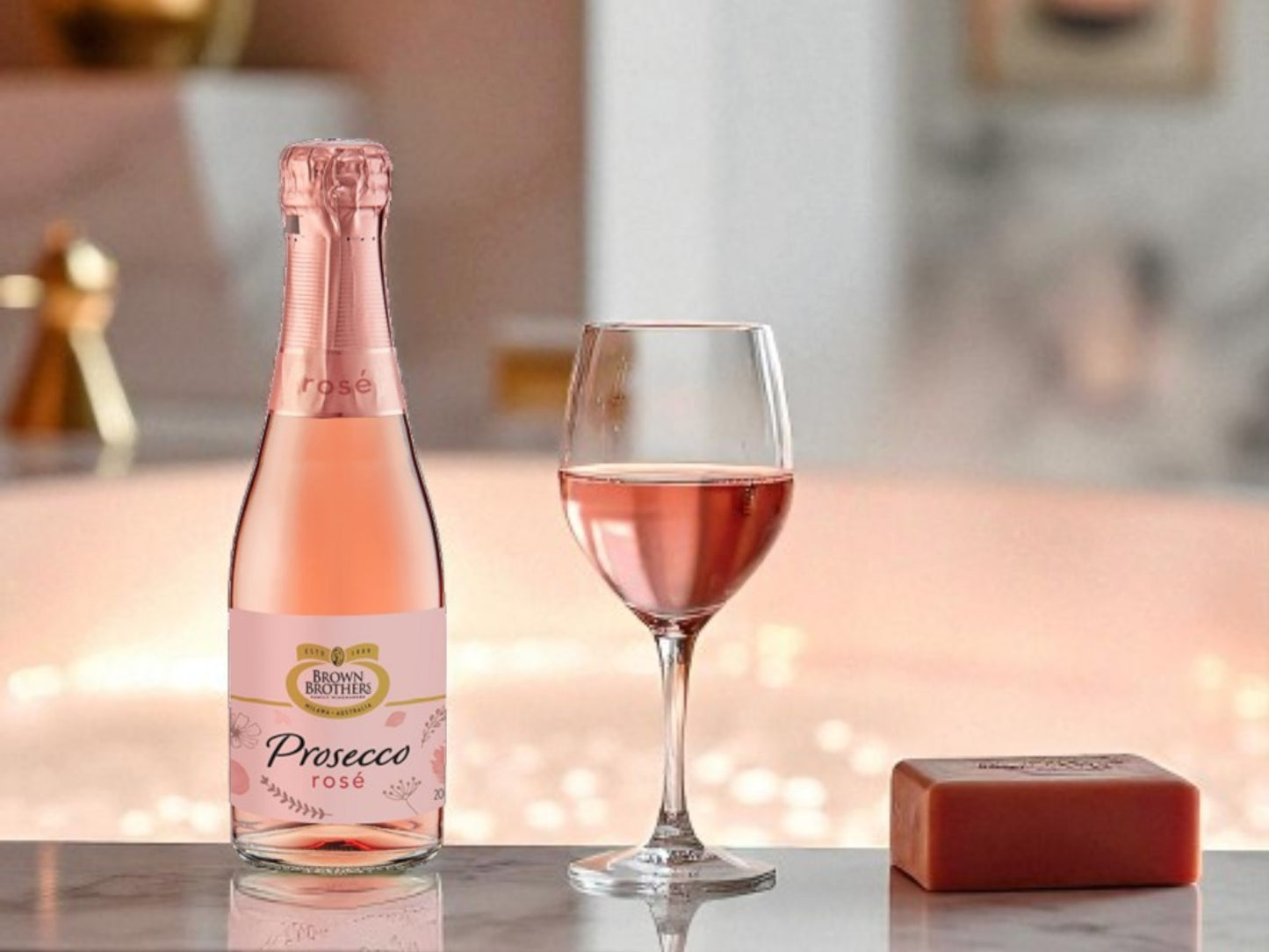 Bottle and glass of Prosecco Rose on a table with blurred background