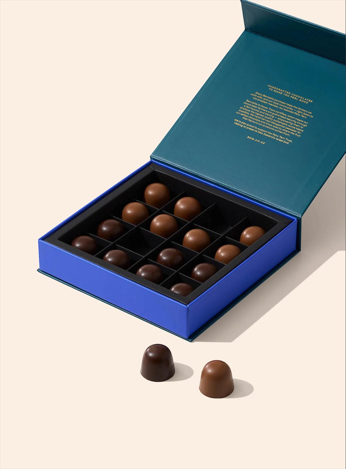 Open blue chocolate box with chocolates on a beige background