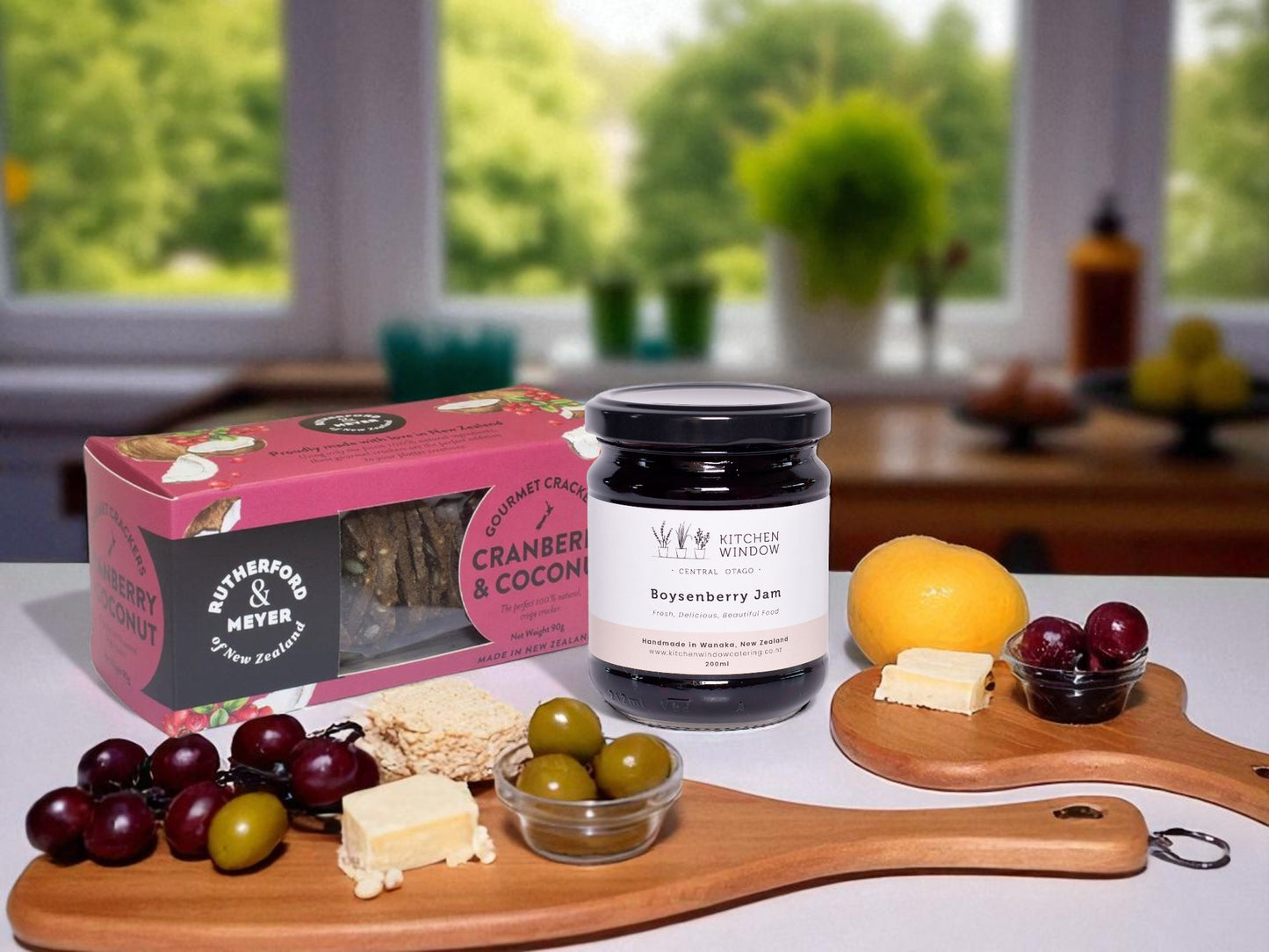 Assorted food items including a jar of jam, crackers, and fruits on a table with a blurred background.